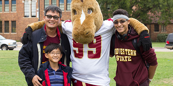 Father and two sons standing together on campus celebrating Family Day event.