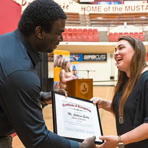 A professor is awarded with a Certificate of Recognition during an MSU Texas awards ceremony.