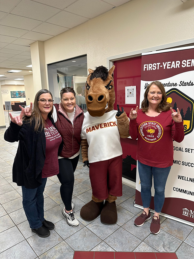 Maverick the Mustang posing with a group of employees inside Clark Student center on March 10, 2023.