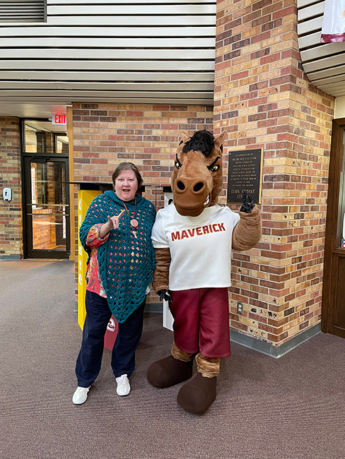 Maverick the Mustang posing with Julie Scales inside Clark Student Center on March 10, 2023.