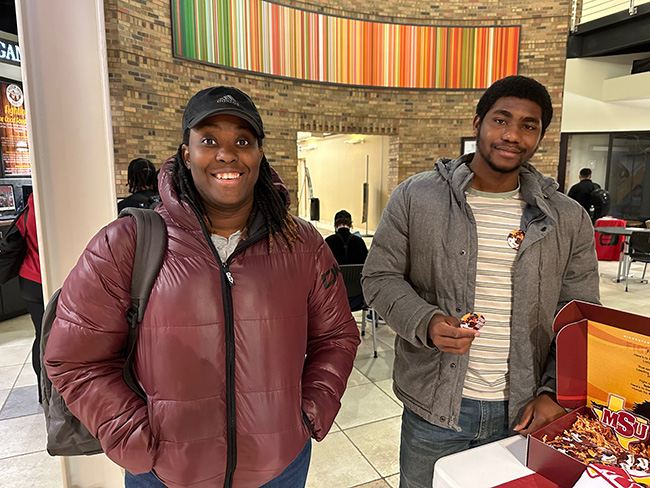 Students posing in the lobby of the Dillard College of Business Administration, March 8, 2023.
