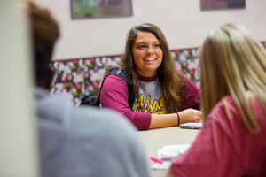 Student sitting at a table smiling