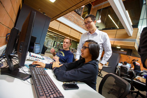 Students with a staff memberat a computer