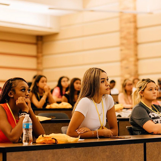 A group of students listen intently while in a lecture in Dillard College of Business Administration.