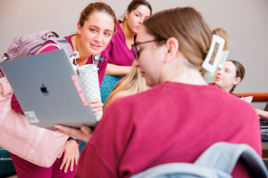 Nursing students looking at a laptop