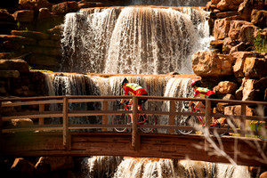 Bike riders in front of the water fall