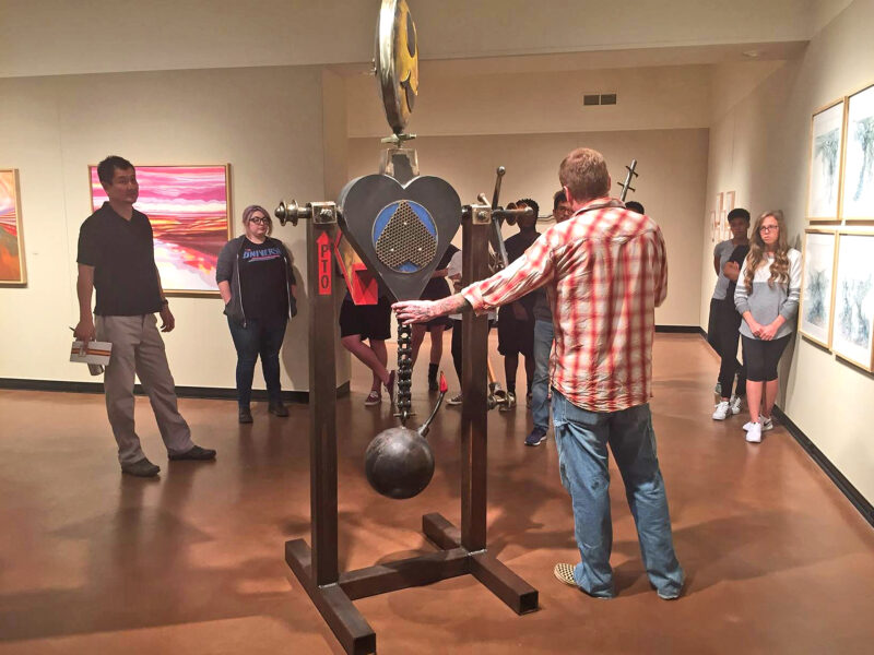 Artist speaking with people in the Juanita Harvey Art Galllery