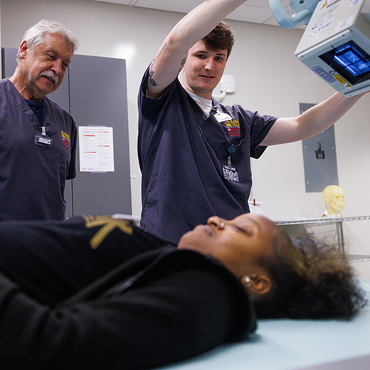 Three Radiologic Science students work together in a simulation.