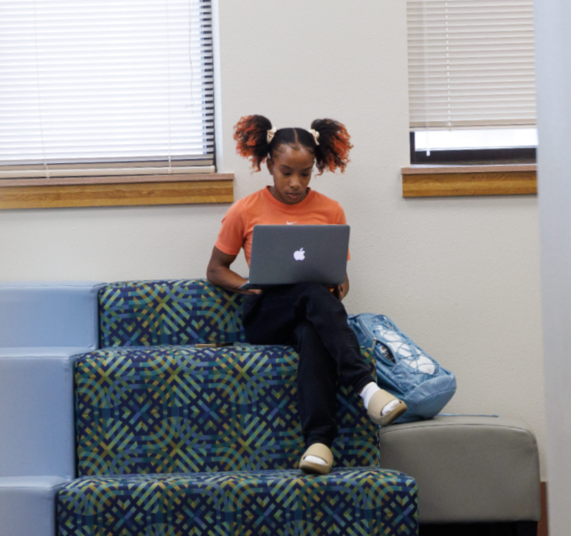 Student looking at a laptop in a building.