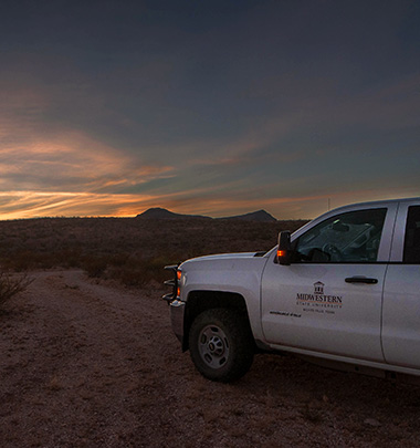Midwestern State University truck with a sunset in the background at Dalquest Desert Research Station in Terlingua, Texas.