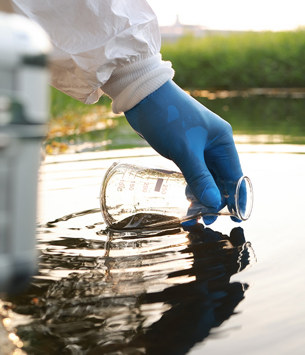 Scientist collects water to perform water safety testing.