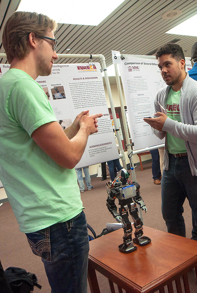 Two students pose with their robot they built and presented during EURECA, for undergraduate research, at MSU Texas.