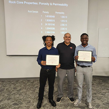 Two students happily pose with their certificates and professor during UGROW, where they conducted undergraduate research in Geosciences.