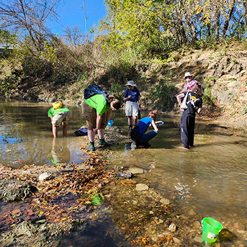A group of Geosciences students work with their professor to collect water.