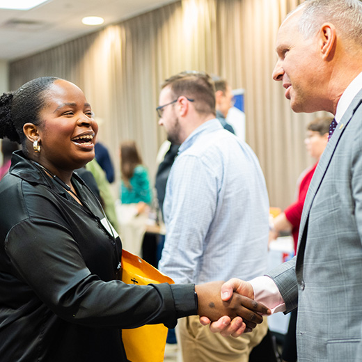 A student shakes hand with a potential employer at the Career Fair hosted by the Career Management Center.