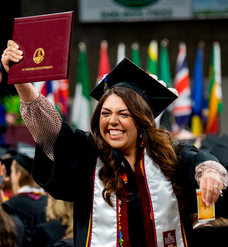 A young lady at graduation holding her diploma