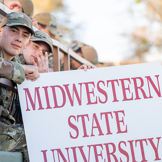 A group of airmen hold up a Midwestern State University sign during the military appreciation football game.