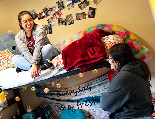 Two students chat while hanging out in their dorm.