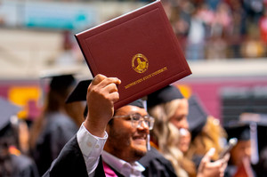 A male student with a diploma