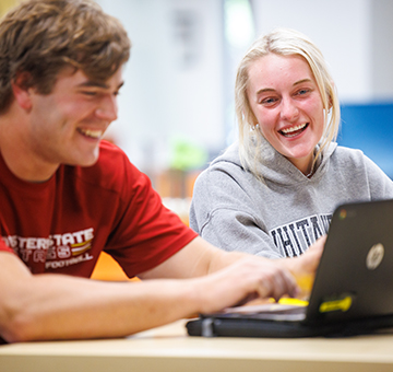 Two students work together in Moffett Library during a study session.