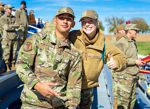 Two United States Air Force members smile and give a thumbs up during an MSU Texas event.