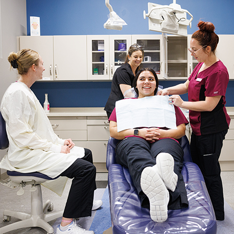 A dental hygiene student performs a teeth cleaning.