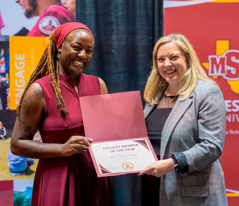 Two employees holding a certificate