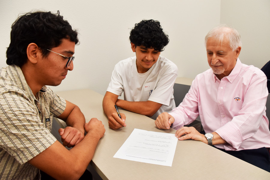 Teacher helping two students
