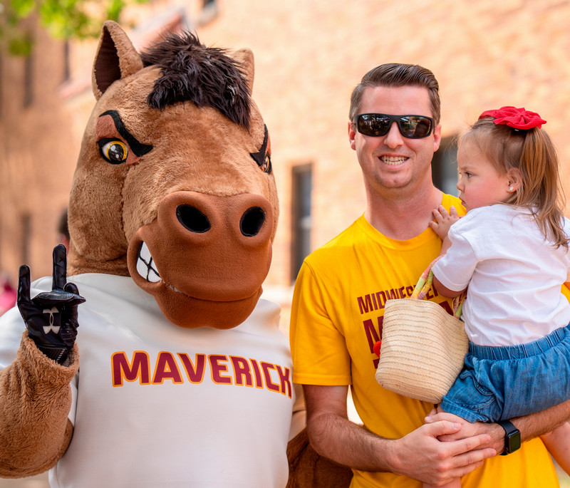 MSU mascot Maverick with father and daughter