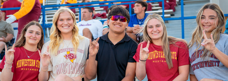 Five students in the stands with stangs up