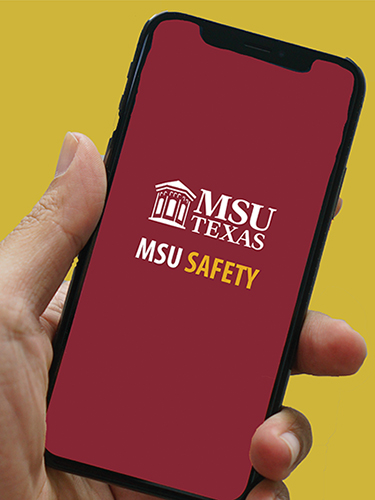 A person holds an iPhone with the MSU Texas MSU Safety app on its screen.