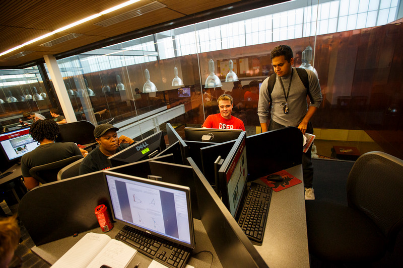 Three engineering students with computers.